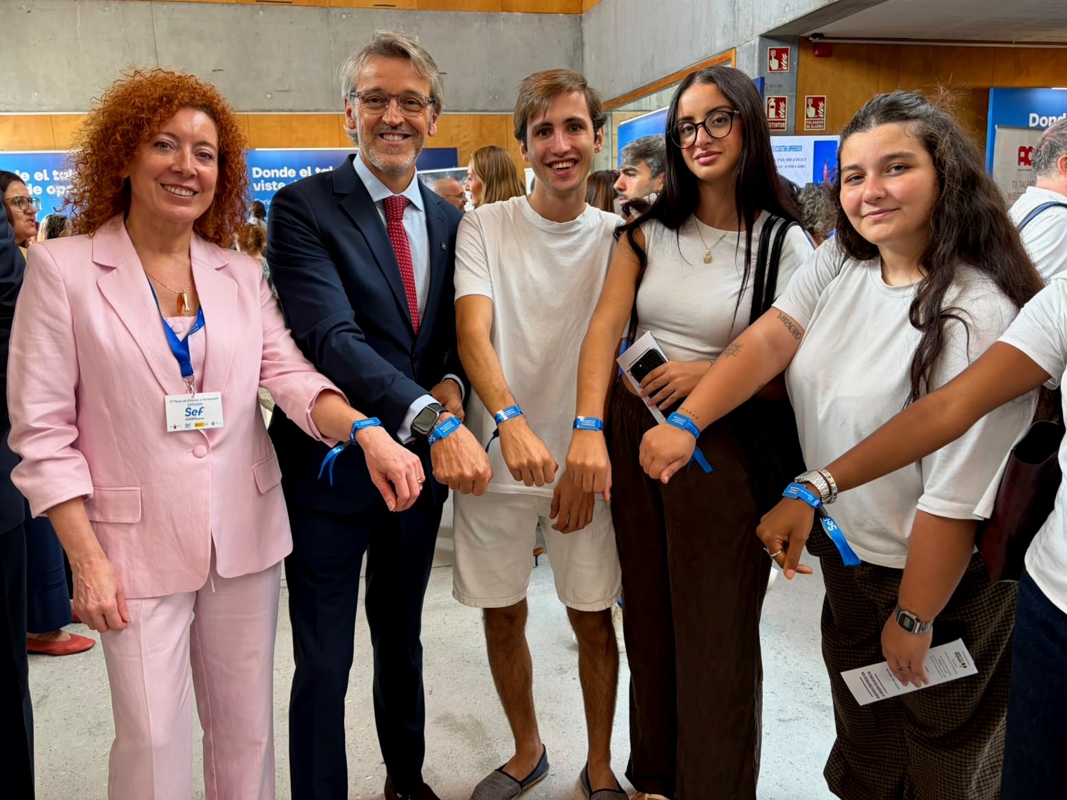 El consejero de Empleo, Luis Alberto Mar&iacute;n, la directora del SEF, Pilar Valero, y un grupo de asistentes a la V Feria de Empleo muestran las pulseras...